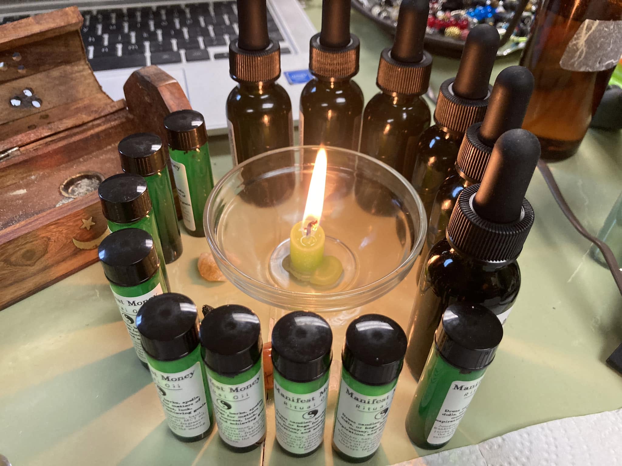 Handcrafted ritual oils arranged around a candle.