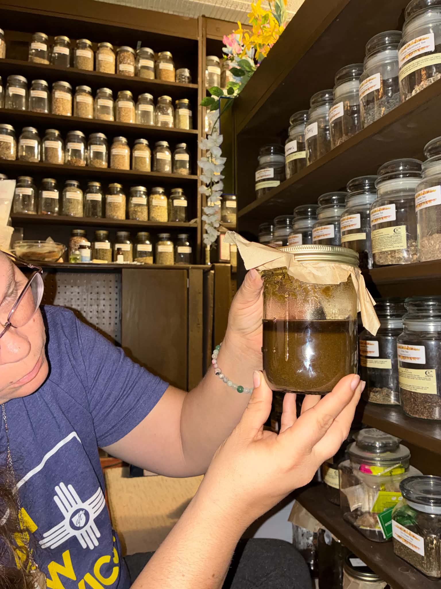 Heather examining a tincture in the herb room